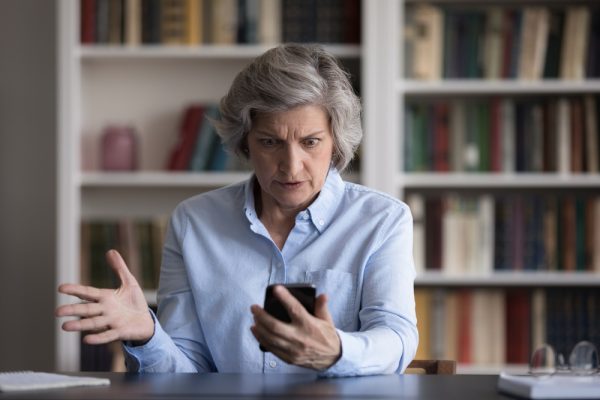 Angry,Nervous,Middle,Aged,Woman,Looking,At,Cellphone,Screen,,Feeling